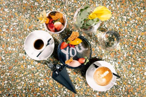 a table with a bowl of fruit and a cup of coffee at Le Méridien Vienna in Vienna