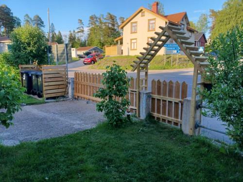 uma cerca de madeira em frente a uma casa em Stop at The Cross em Borås