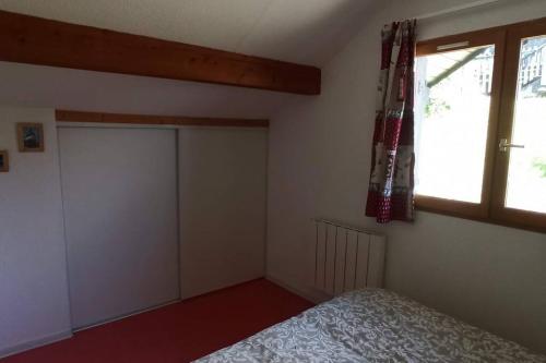 a bedroom with a bed and a window and a door at Appartement duplex au pied des pistes in Le Dévoluy