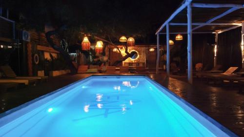 a blue swimming pool at night with lights at NENA BEACH CLUB & HOTEL in Baru