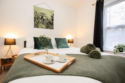 - 2 lits dans une chambre avec un plateau de tasses à café dans l'établissement Modern, stylish city centre 3 bed property sleeps 6, à Lincoln