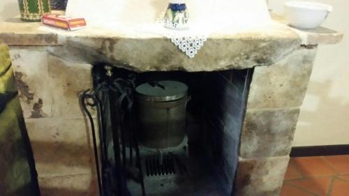 uma lareira de pedra com um lavatório e uma lata de lixo em La Casa Sù Le Dimore Del Borgo em Santo Stefano di Sessanio