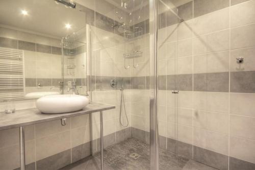 uma casa de banho com uma cabina de duche em vidro e um lavatório. em Gîte Darcey la Jolie 6/8 pers. em Darcey