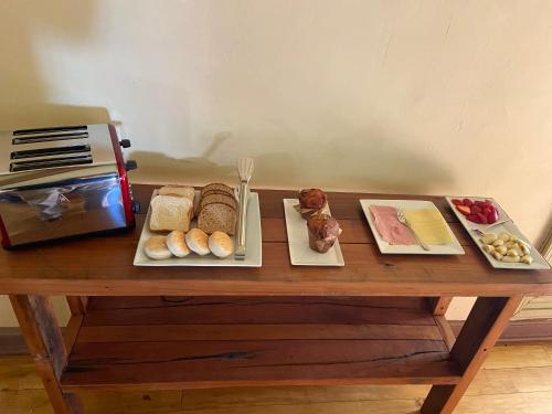 a wooden table with bread and other foods on it at CASONA SAN PEDRO Hotel Boutique in San Javier
