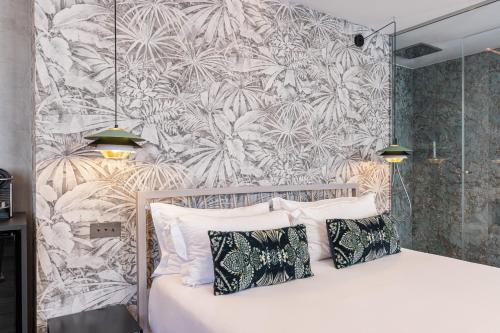 a bedroom with a bed with a tropical wallpaper at Le Dortoir Boutique Suites in Nice