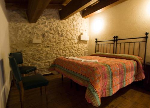 een slaapkamer met een bed en een stoel bij La Casa Sù Le Dimore Del Borgo in Santo Stefano di Sessanio