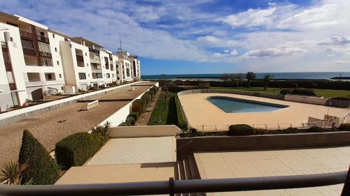 - une vue depuis le balcon d'un immeuble avec piscine dans l'établissement RIVAGES DE ROCHELONGUE Joli T2 piscine vue mer Rochelongue Cap d'Agde, au Cap d'Agde