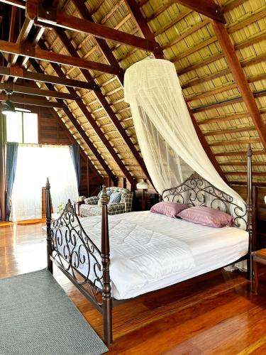 a bedroom with a bed with a mosquito net at RuenKijja in Ban Kroen