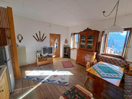 a living room with a tv and a table at L' antica Casa di Maria Lilia in Pieve di Cadore