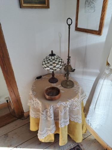 a table with a lamp on top of it at L' antica Casa di Maria Lilia in Pieve di Cadore
