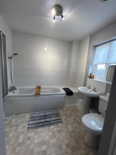 a bathroom with a tub and a toilet and a sink at Spacious 5-bedroom nr Swanpool Beach - Falmouth in Falmouth