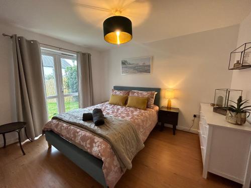 a bedroom with a bed and a large window at Spacious 5-bedroom nr Swanpool Beach - Falmouth in Falmouth