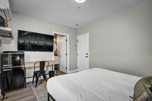 ein weißes Schlafzimmer mit einem Schreibtisch und einem Bett in der Unterkunft Single Bedroom - Queen Size. Heart of Downtown Vista in Vista