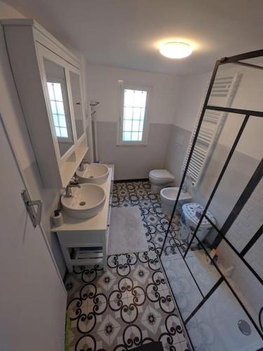 ein Badezimmer mit zwei Waschbecken und einem WC in der Unterkunft Casa di Nico in Finale Ligure