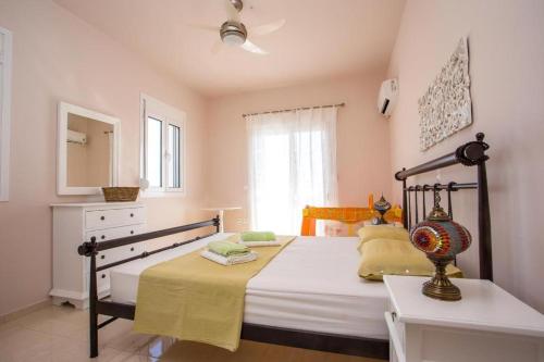 a bedroom with a bed and a dresser and a window at Villa Regina - Double Pool Paradise in Lachania