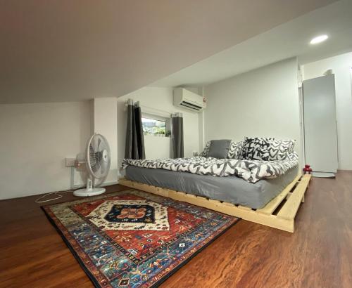 a bedroom with a bed with a rug and a fan at Sweet Loft Homestay in Johor Bahru