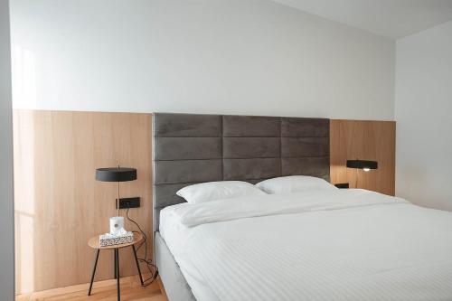 sypialnia z dużym białym łóżkiem z zagłówkiem w obiekcie 26 Bricks Suites w mieście Oradea