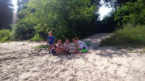 a group of children sitting in the sand on the beach at GALATA house along the river Danube in Radvaň nad Dunajom