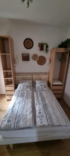 un grande letto in una stanza con alcuni scaffali di appartement meublé romain a Niederbronn-les-Bains