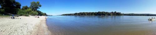 a view of a beach with a boat in the water at GALATA house along the river Danube in Radvaň nad Dunajom