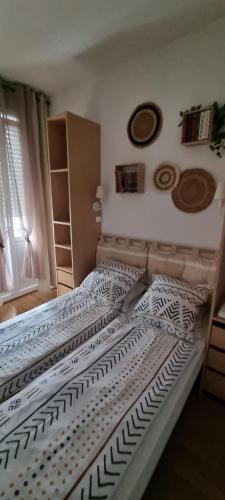 una camera da letto con un grande letto con lenzuola bianche e nere di appartement meublé romain a Niederbronn-les-Bains