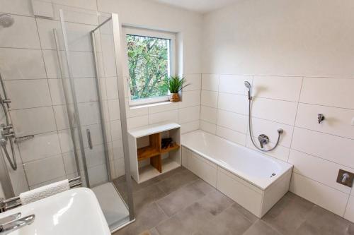 a bathroom with a tub and a shower and a sink at Große COZY 3-Zi-Whg mit Balkon Nähe Europa Park und Rulantica in Lahr