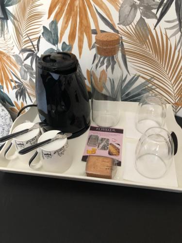 - un plateau avec un vase noir et des verres dans l'établissement L'escapade champenoise, à Villers-Marmery