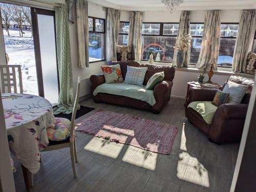 un soggiorno con divano e tavolo di Ferny Roost Cabin. a Wrexham