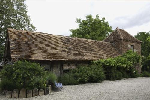 an old brick house with a shingled roof at Marguerite's Ferme rustique in Saint-Germain-du-Bois