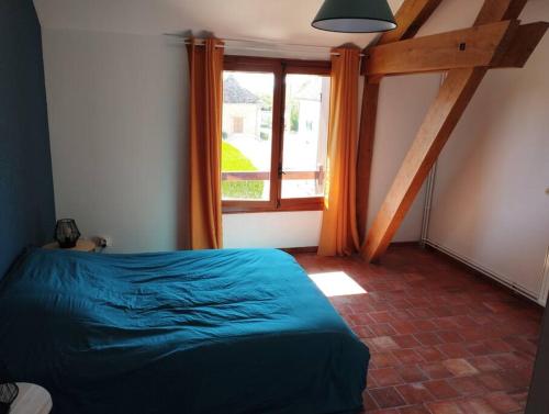 a bedroom with a bed and a large window at Appartement dans village calme à 5 min des lacs in Mathaux