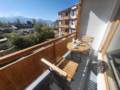 a balcony with two chairs and a table on it at Hotel Amanthi Ladakh in Leh