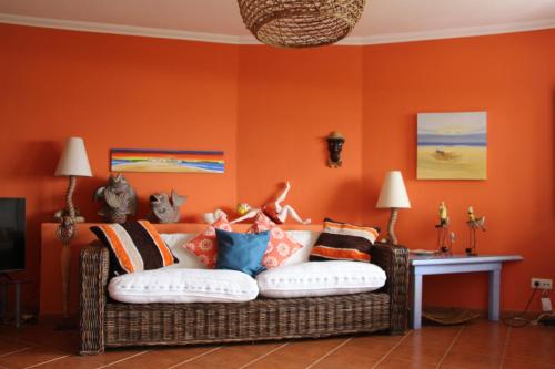sala de estar con sofá y paredes de color naranja en Baleal, by the sea with swimming pool, en Baleal