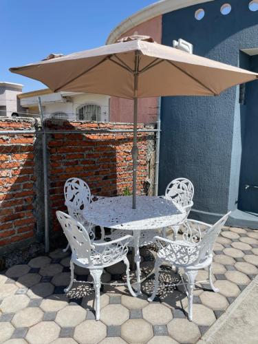a table and chairs with an umbrella on a patio at Casa Málaga in Zamora de Hidalgo
