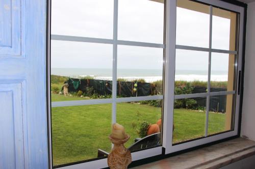 una ventana con vistas al océano a través de ella en Baleal, by the sea with swimming pool, en Baleal