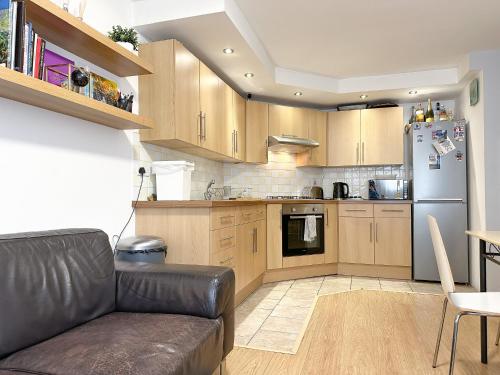 a living room with a couch and a kitchen at Cool Place 02 Academy in London