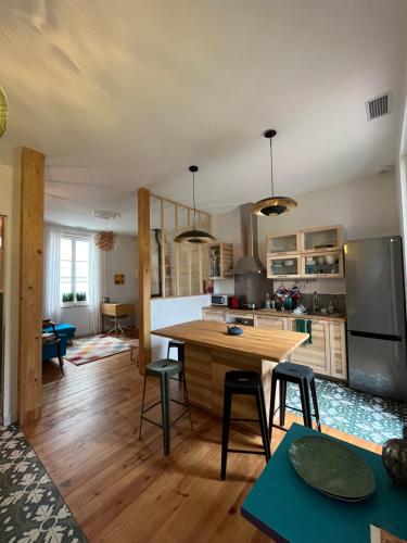 - une cuisine avec une table en bois et des chaises dans l'établissement Maison d'hôtes Alma, à Bordeaux