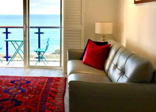 a living room with a couch and a view of the ocean at Stylish Sea View Apartment with Parking in Penzance