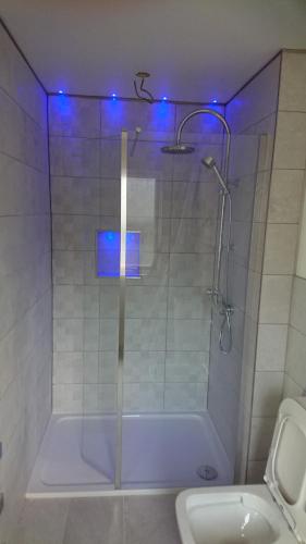 a bathroom with a shower with blue lights in it at Sea Breezes in Oban