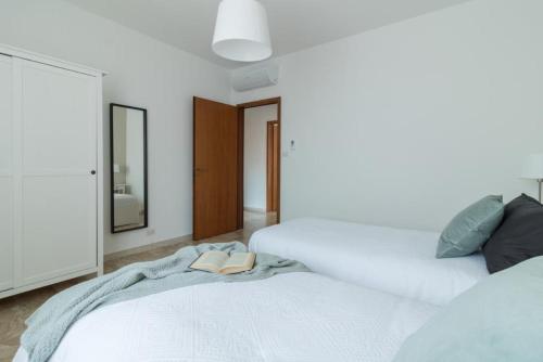 a white bedroom with two beds and a mirror at Italianflat - Via Adami, 3 Bedroom Flat, FREE PARKING in Verona