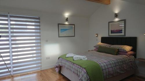 a bedroom with a bed and a large window at Sea Breezes in Oban