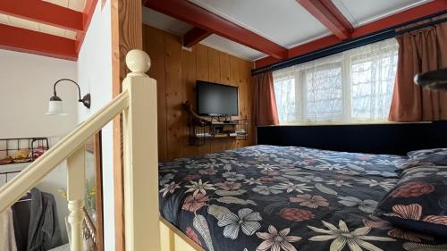 um quarto com uma cama com colcha floral em Onze Logeerkamer em Deil