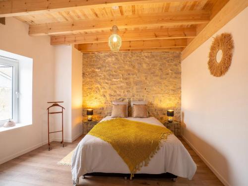 1 dormitorio con 1 cama con pared de piedra en Spacious holiday home in Doische with private pool, en Doische