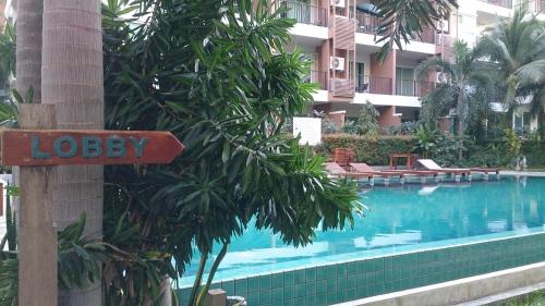 a sign on a pole next to a swimming pool at Diamond Suite in Pattaya South