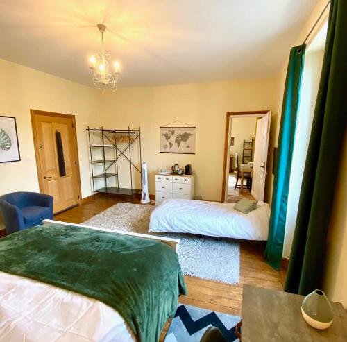 a bedroom with two beds and a chandelier at Le Portanel in Eymet