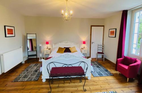 sypialnia z białym łóżkiem i różowym krzesłem w obiekcie Le Portanel w mieście Eymet