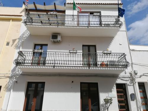 a white apartment building with a balcony at Terra Sinus Beautiful Suite in Terrasini