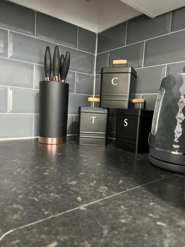 a counter with three black containers with forks in them at Apartment in St Denys in Southampton