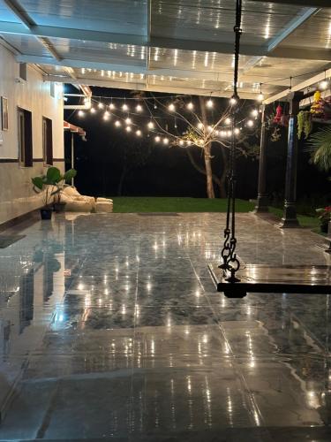 a patio with a pool with lights on it at Rustic Village Farmhouse in Bengaluru