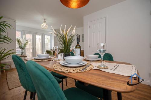 uma sala de jantar com uma mesa de madeira e cadeiras verdes em Ironside House, king or twin beds, free parking, workspace, free wi-fi, corporates, pets, sleeps 8 em Thrapston