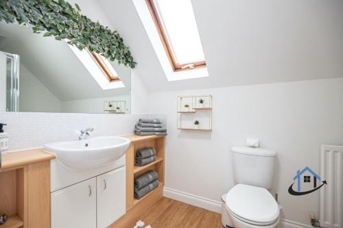 a bathroom with a sink and a toilet with skylights at Ironside House, king or twin beds, free parking, workspace, free wi-fi, corporates, pets, sleeps 8 in Thrapston